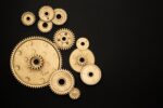 Golden cogs of various sizes on a black background