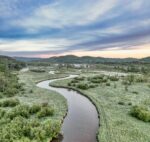 River meanders through green fields