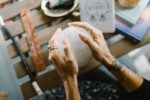 Hands holding a crystal ball above a wooden table