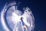 This image shows a ferris wheel at night. It has been taken with a long exposure so the lights on the wheel show the rotation of the wheel.